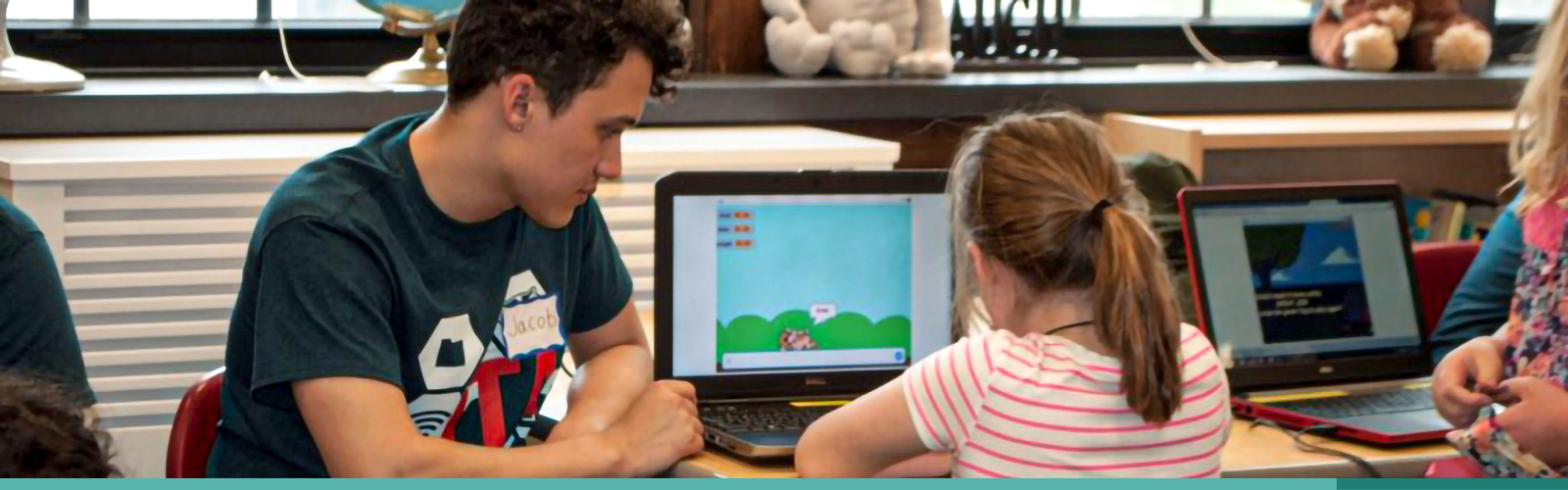 ITA student sitting with a young girl at a laptop