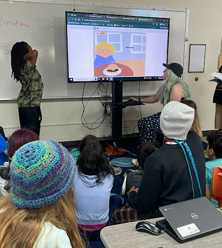 Orchard Ridge 5th Grade Student presenting their game proposal, along with Teacher playing ITA student’s resulting game. ITA Roadshow, May 29, 2024.